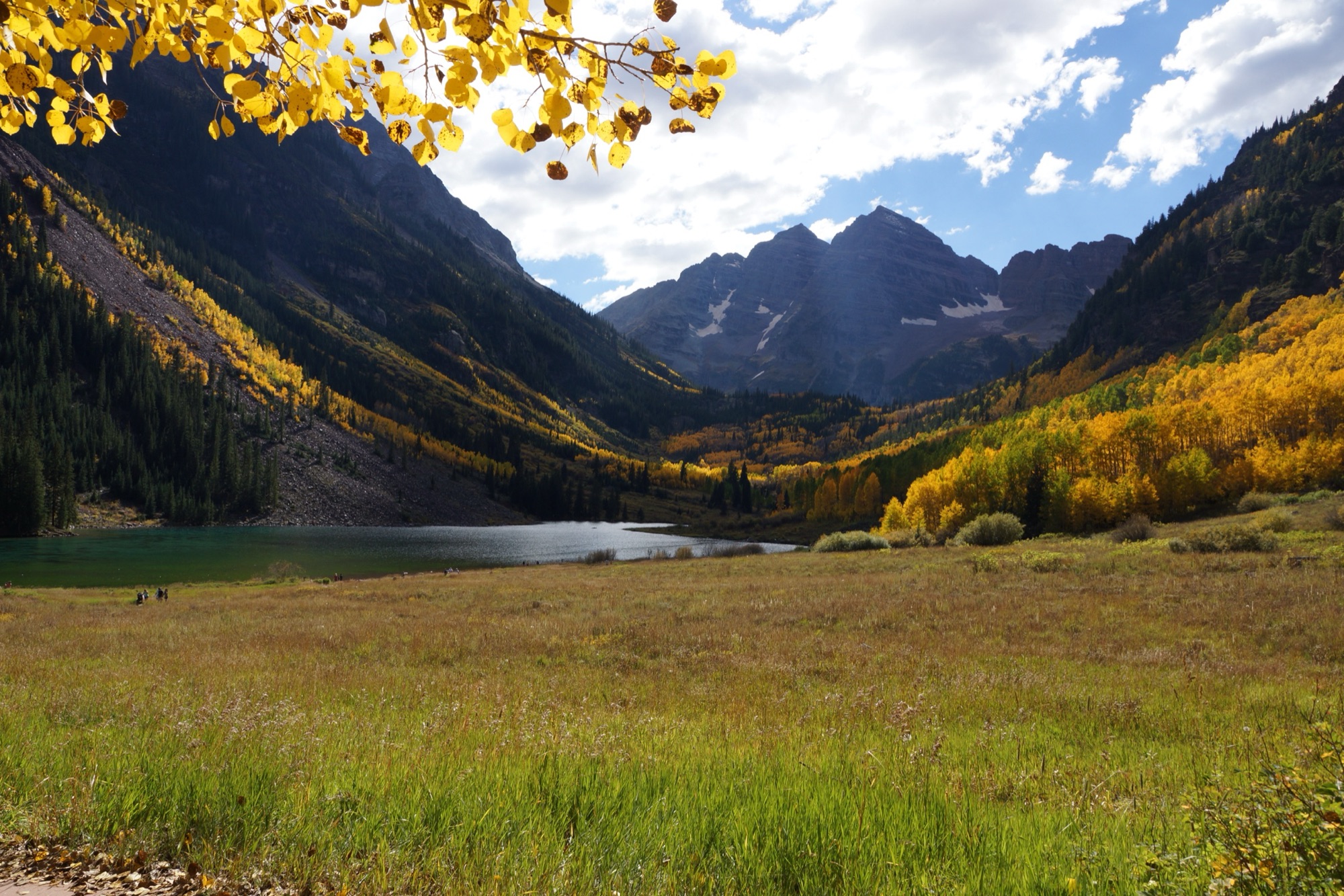 The Maroon Bells rising above Maroon Lake in autumn, golden aspens filling the valley below