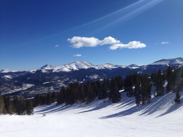The snowy Tenmile Range across the valley from a groomed ski run above the town of Breckenridge