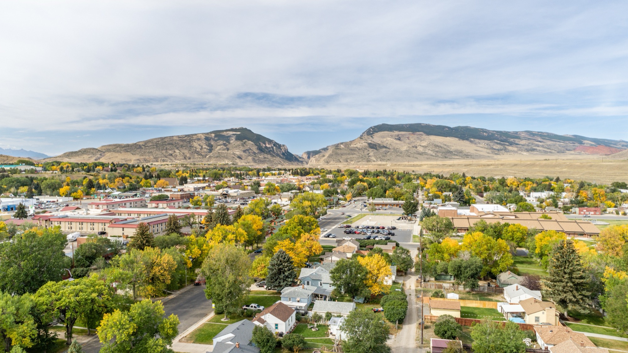 An autumn aerial of Cody, Wyoming, with golden cottonwoods and Cedar Mountain behind