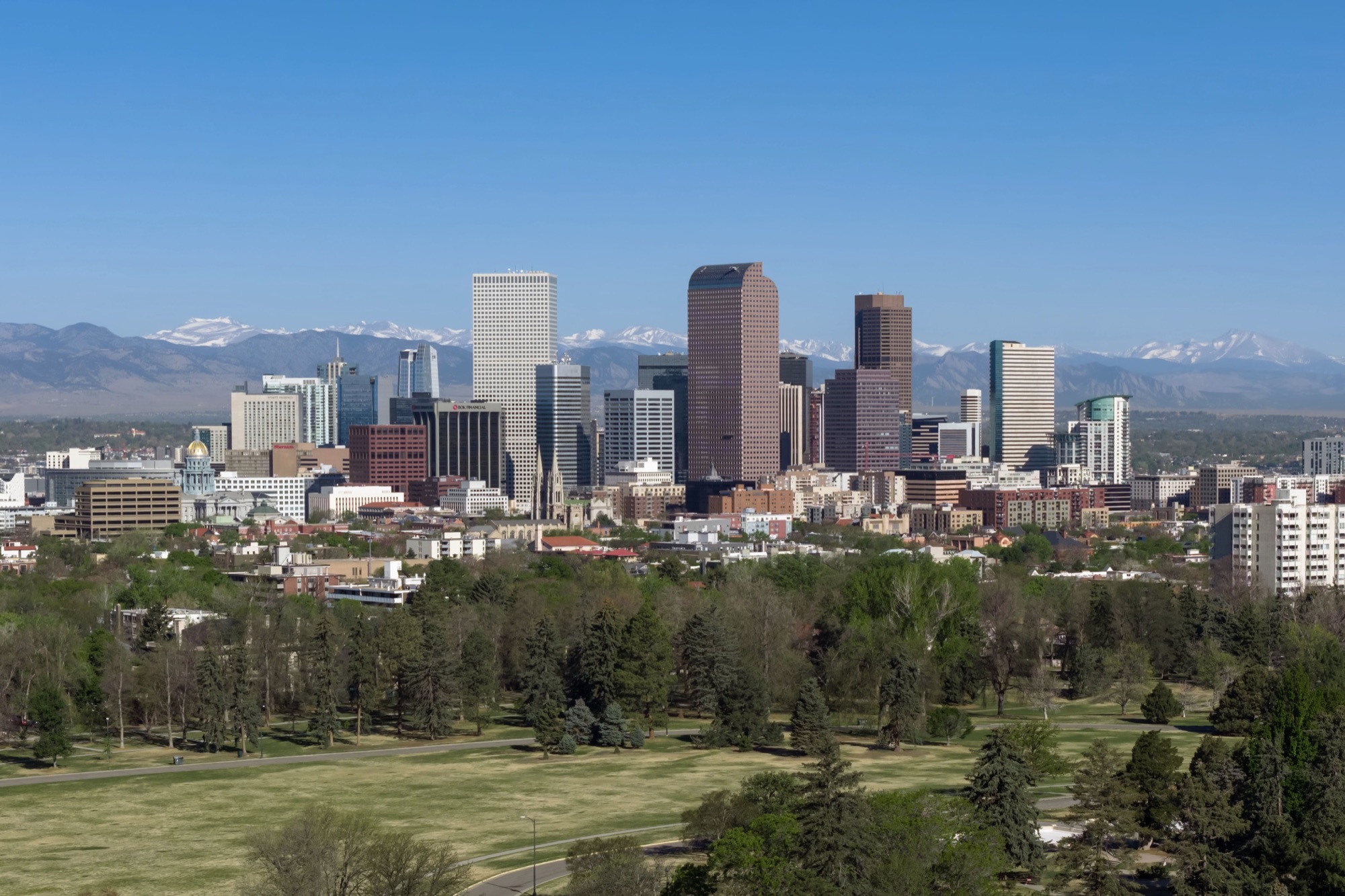 The downtown Denver skyline with the snow-capped Rocky Mountains rising behind it