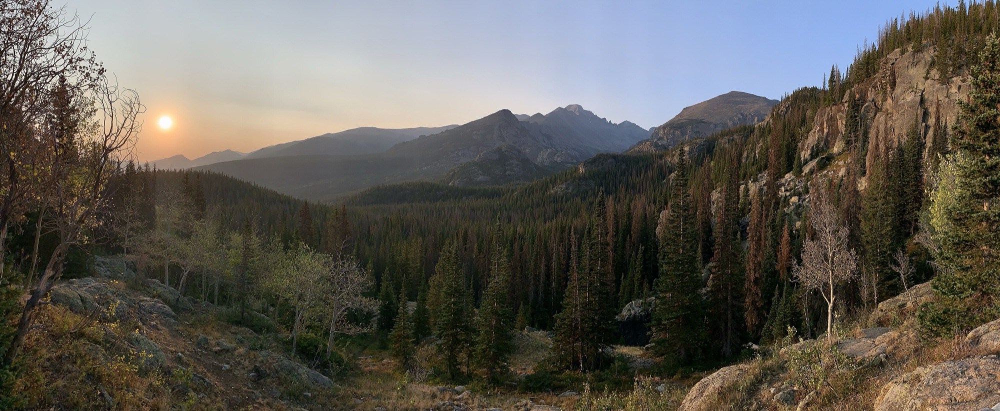Sunrise over the mountains and forested valley along the Dream Lake Trail in Rocky Mountain National Park