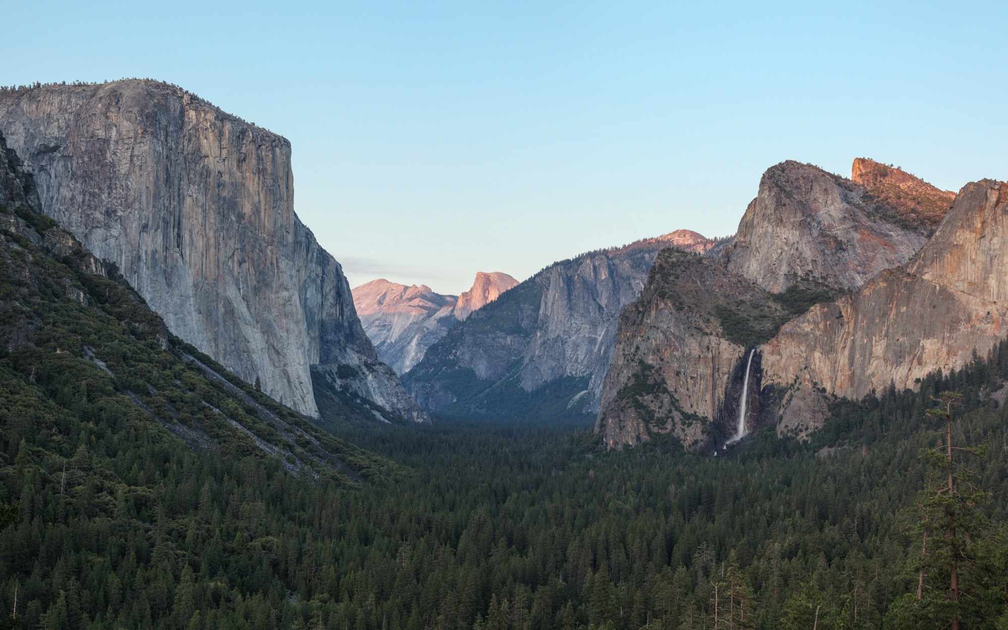 The classic Tunnel View of Yosemite Valley at sunset — El Capitan, Bridalveil Fall, and alpenglow on Half Dome