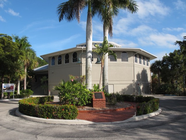 The exterior of the Bailey-Matthews National Shell Museum in Sanibel — a tan octagonal building with arched clerestory windows and royal palms