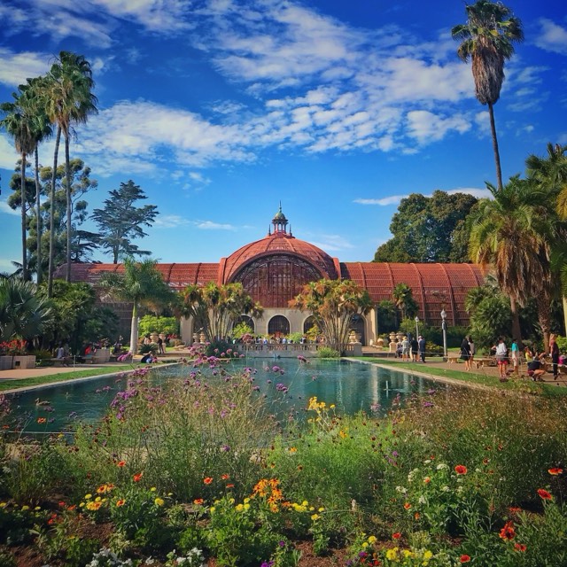 The lily pond and gardens before Balboa Park's historic lath Botanical Building
