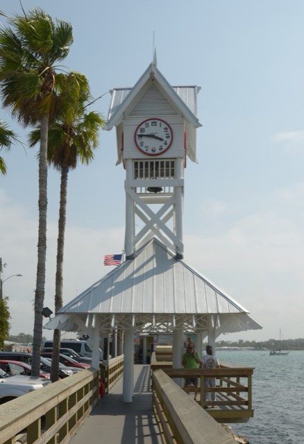 The white clock-tower entrance building of the Historic Bridge Street Pier reaching over the water at Bradenton Beach, Anna Maria Island