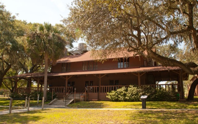 The historic wooden lodge under live oaks at Camp Helen State Park