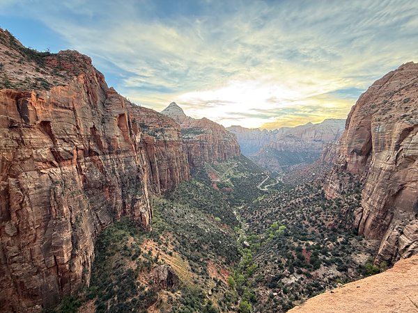 Canyon Overlook at sunset — red walls framing Zion Canyon and the Mt. Carmel switchbacks