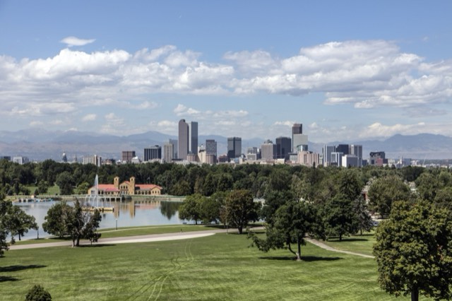 The Denver skyline and Rockies beyond Ferril Lake and the boathouse in City Park