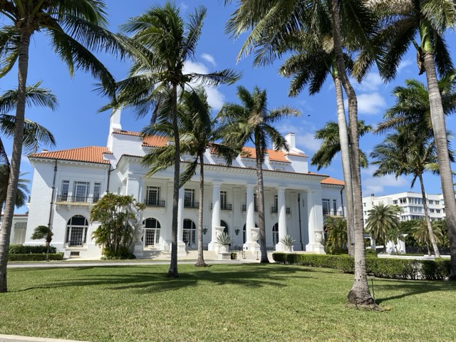 The white Beaux-Arts facade of Whitehall, the Flagler Museum, framed by royal palms in Palm Beach