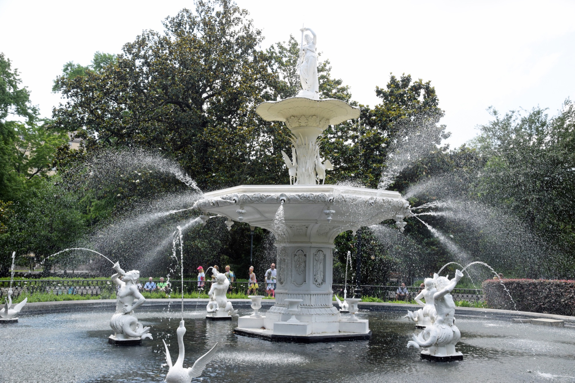 The white two-tier cast-iron fountain at Forsyth Park in Savannah, framed by live oaks draped in Spanish moss
