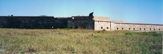 The historic brick bastion walls of Fort Pickens, topped by a cannon, at Gulf Islands National Seashore