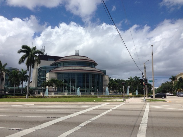 The domed, glass-fronted Kravis Center for the Performing Arts with blue fountains and palms in West Palm Beach