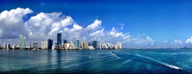 The downtown Miami and Brickell skyline rising across Biscayne Bay, seen from the Rickenbacker Causeway with boats on the water