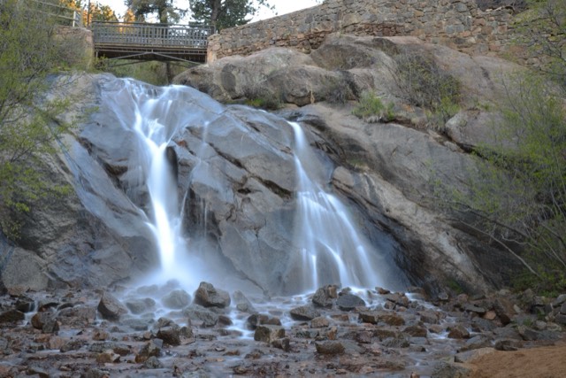 Helen Hunt Falls cascading over granite beneath a stone footbridge in North Cheyenne Canon