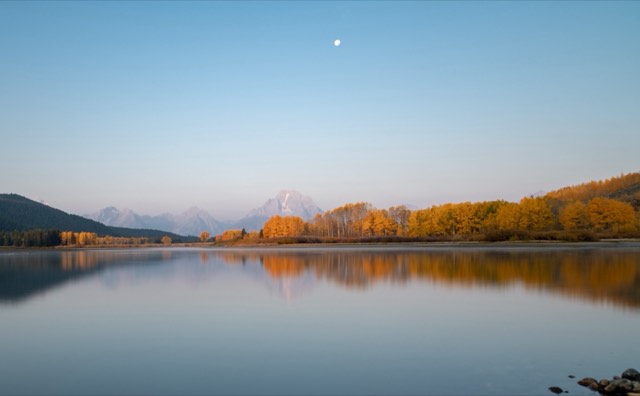 Dawn light and a moon over Mount Moran reflected in the Snake River at Oxbow Bend
