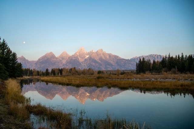 The Teton Range mirrored in the calm Snake River at dawn