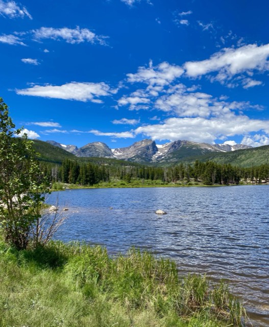The Continental Divide peaks reflected in Sprague Lake on a summer day
