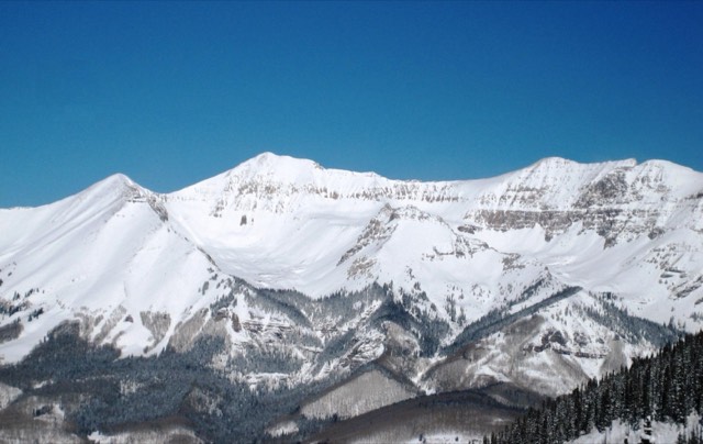 The snowy San Juan peaks of the Telluride ski area above town under a deep blue winter sky
