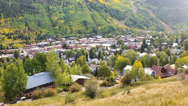 The town of Telluride on the valley floor, seen from the Imogene Pass road amid early aspen color