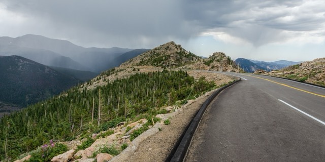 Trail Ridge Road curving across the alpine tundra as a storm sweeps the distant peaks