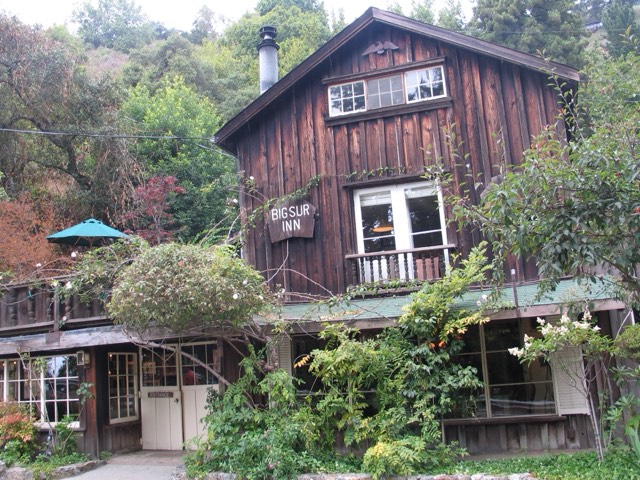 The weathered redwood facade of Deetjen's Big Sur Inn with its 'Big Sur Inn' sign and garden
