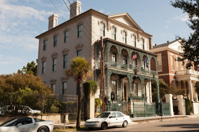 The John Rutledge House Inn — the 1763 house with its ornate tiered green ironwork balconies and flags on Broad Street, Charleston