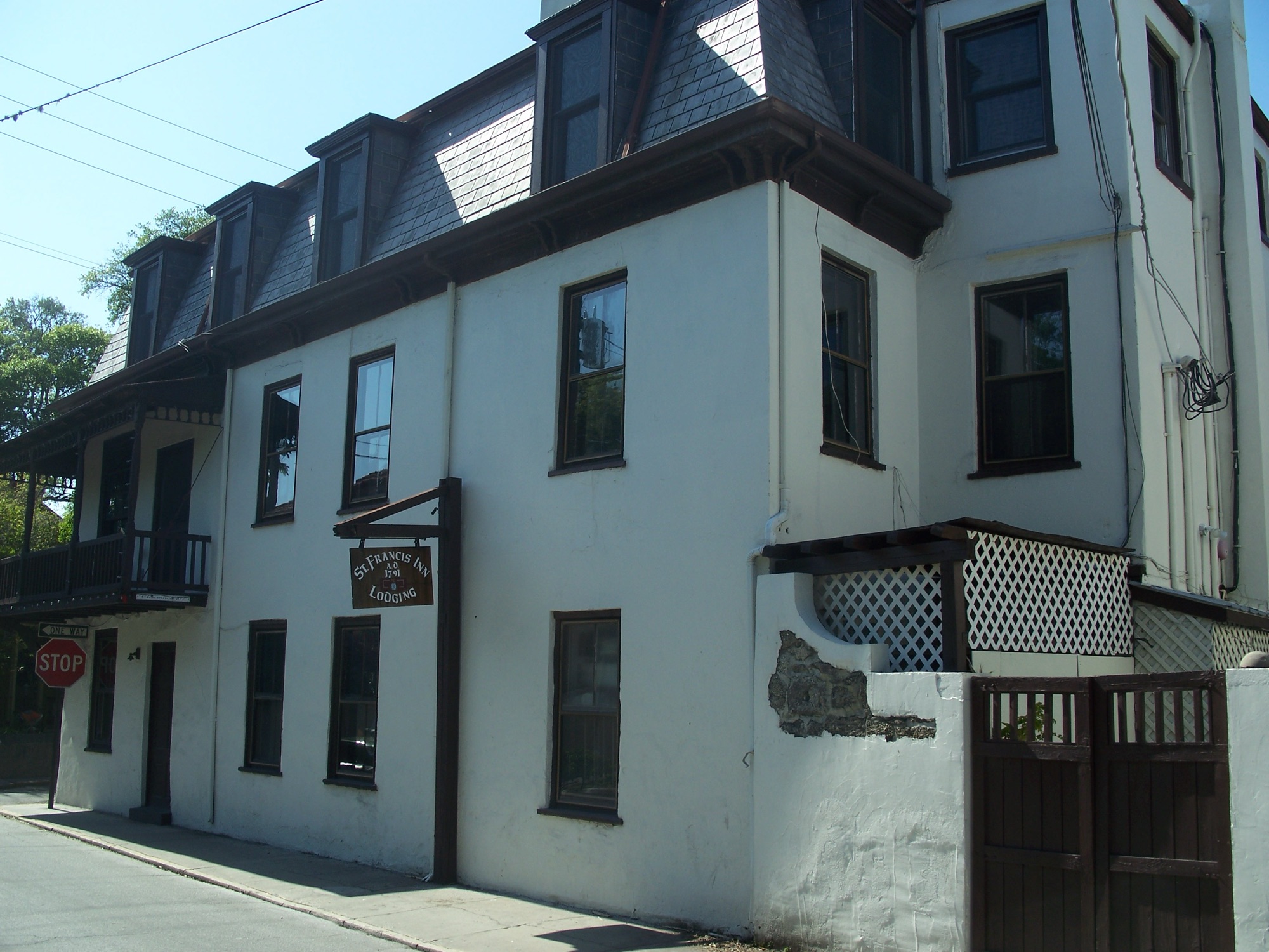 The St. Francis Inn — a 1791 coquina-and-stucco building with a mansard roof and hanging 'St. Francis Inn Lodging' sign in St. Augustine's Old Town