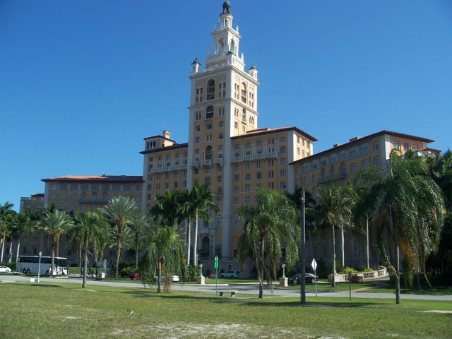The Biltmore Hotel's Giralda-inspired tower rising over its Mediterranean Revival facade and a row of palms in Coral Gables, Miami