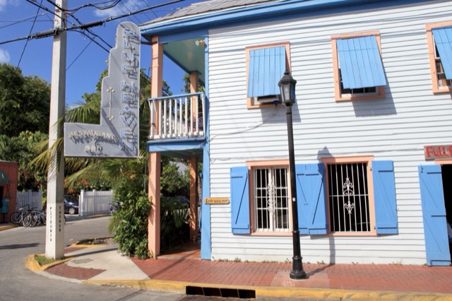 The white-clapboard, blue-shuttered corner exterior of Blue Heaven restaurant in Key West's Bahama Village