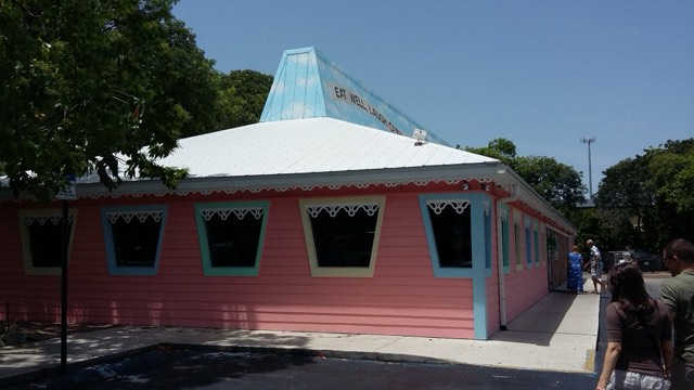 The pink clapboard exterior of Mrs. Mac's Kitchen in Key Largo, with an 'Eat Well, Laugh Often' motto on its blue rooftop cupola