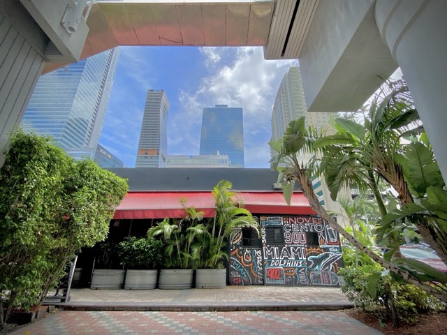 Novecento's red-awninged Brickell storefront and hand-painted mural beneath the downtown Miami towers