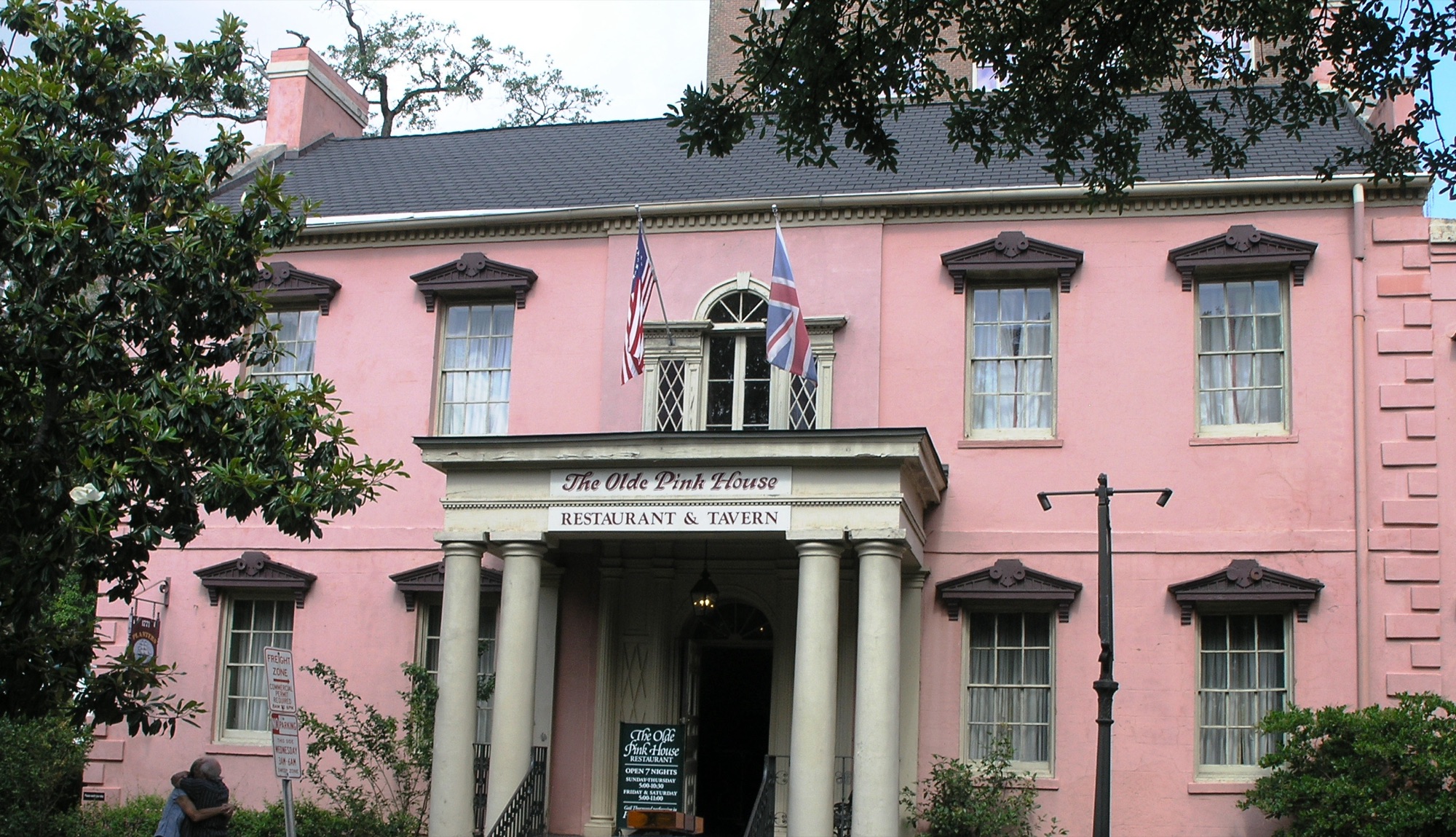 The Olde Pink House — the iconic 1771 pink Georgian mansion with white columns and US and British flags on Reynolds Square, Savannah