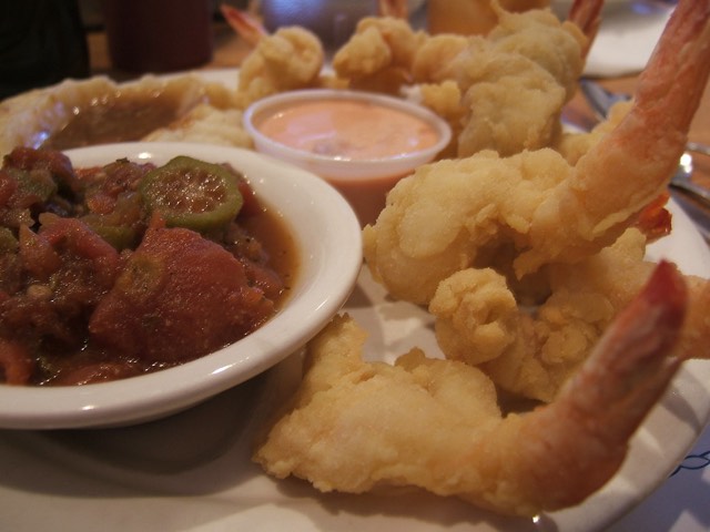 O'Steen's signature fried shrimp with a cup of datil-pepper sauce and a bowl of okra and tomatoes