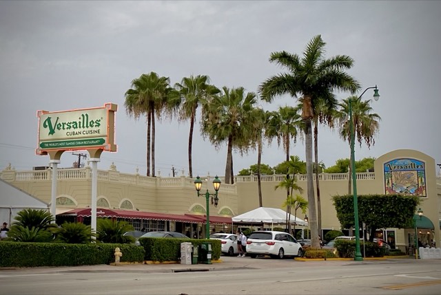 The Versailles Cuban Cuisine neon sign and storefront with royal palms on Calle Ocho, Little Havana, Miami