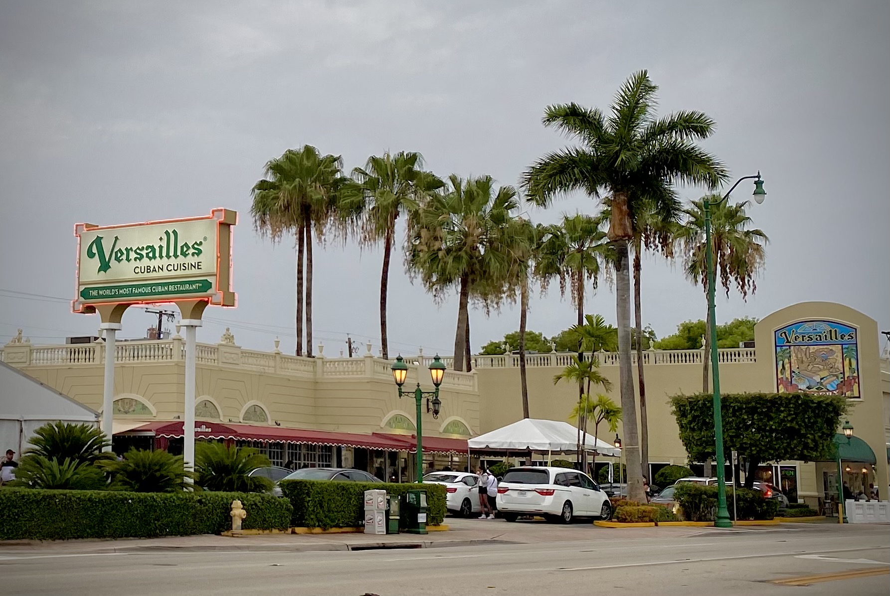 The Versailles Cuban Cuisine neon sign and storefront with royal palms on Calle Ocho, Little Havana, Miami